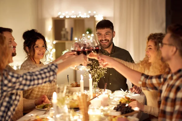 Happy friends drinking red wine at christmas party — Stock Photo, Image