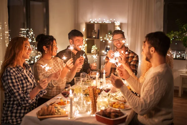 Amigos felices teniendo la cena de Navidad en casa —  Fotos de Stock