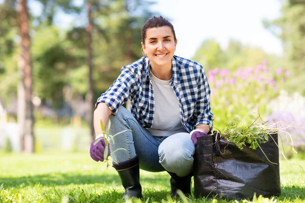 Vrouw wieden bloembed in de zomer tuin — Stockfoto