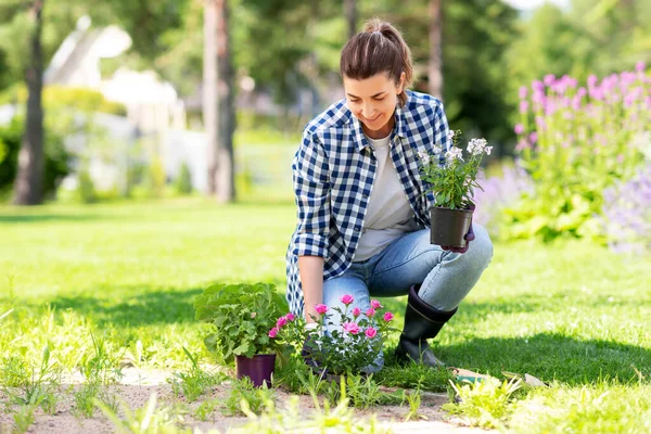 Kvinna plantering ros blommor på sommaren trädgård — Stockfoto