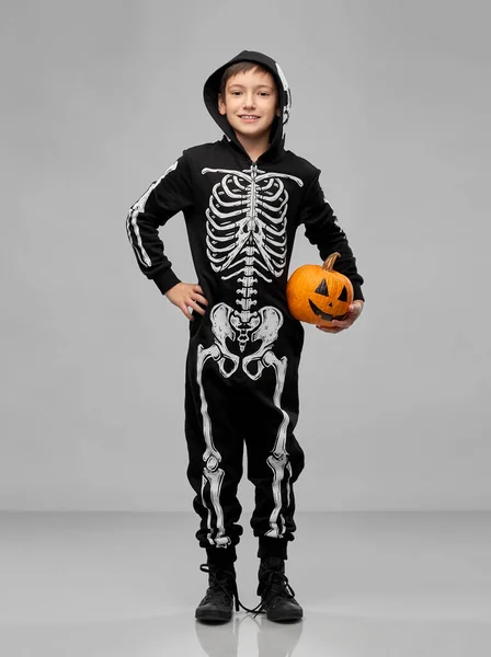 happy boy in halloween costume with jack-o-lantern