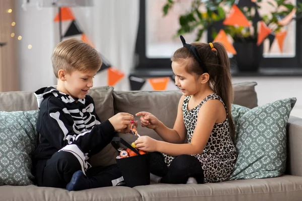 Kinderen in halloween kostuums met snoep thuis — Stockfoto