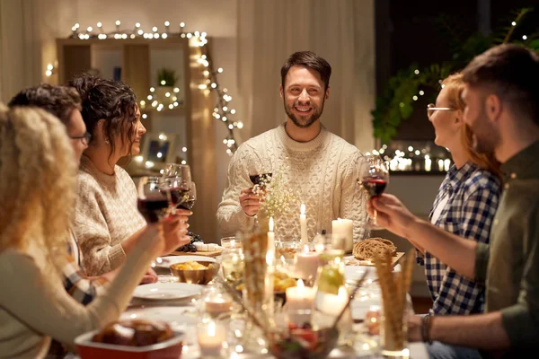 Happy friends drinking red wine at christmas party — Stock Photo, Image