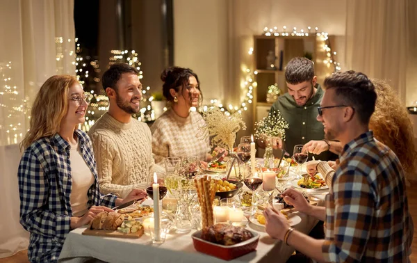 Glada vänner som äter julmiddag hemma — Stockfoto