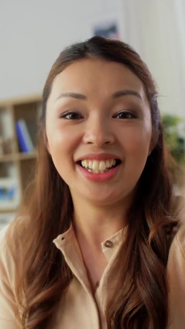 Щаслива молода азіатська жінка має відеодзвінок вдома — стокове відео