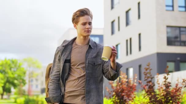 Jonge man met rugzak drinken van koffie in de stad — Stockvideo