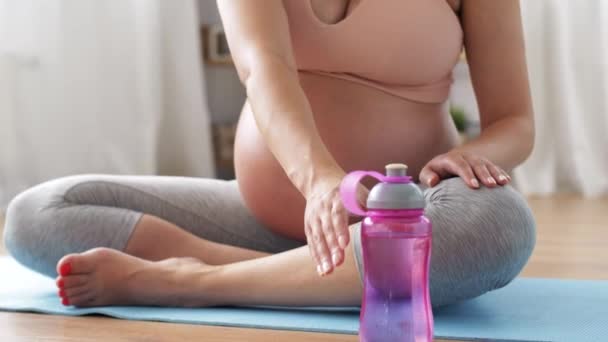 Pregnant woman drinking water after yoga at home — Stock Video