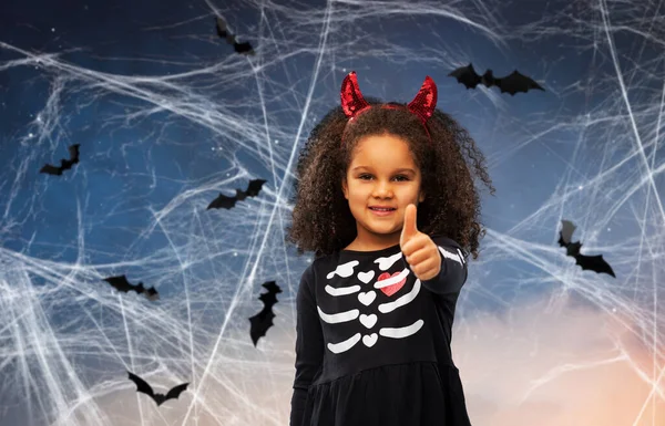 Girl in black dress and devils horns on halloween — Stock Photo, Image