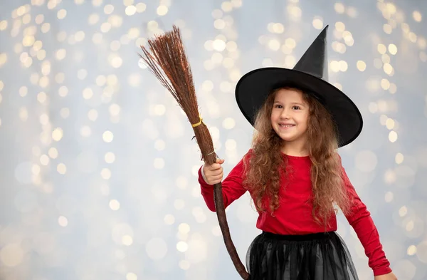 Dziewczyna w czarny wiedźma kapelusz z miotła na halloween — Zdjęcie stockowe