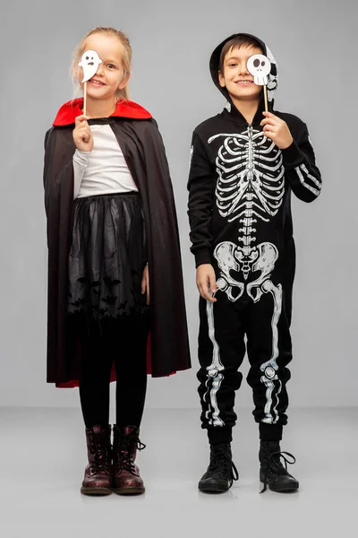 Kinderen in halloween kostuums met party rekwisieten — Stockfoto