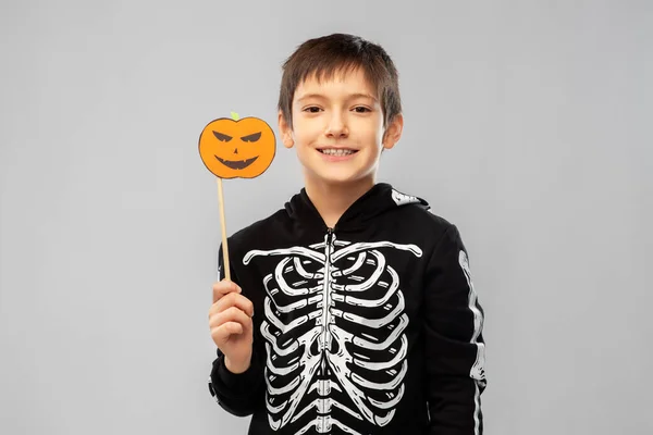 Boy in halloween costume of skeleton with pumpkin — Stock Photo, Image