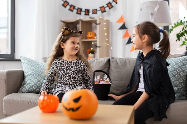 Meninas em trajes de Halloween com doces em casa — Fotografia de Stock