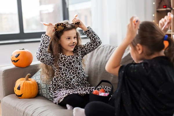 Meninas em trajes de Halloween com doces em casa — Fotografia de Stock