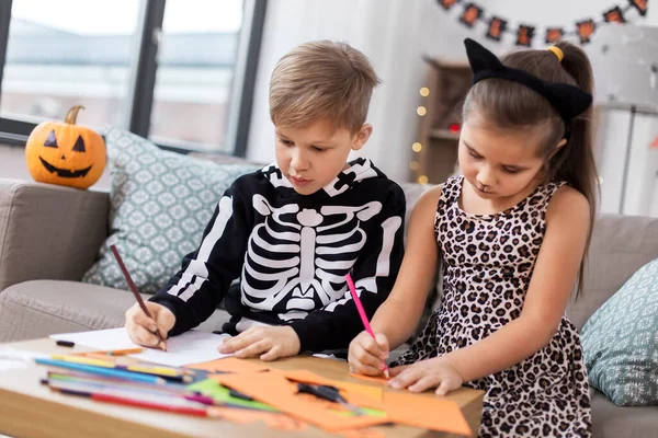 Crianças em trajes de Halloween fazendo artesanato em casa — Fotografia de Stock