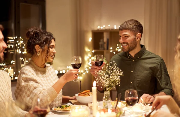 Glückliche Freunde, die auf der Weihnachtsfeier Rotwein trinken — Stockfoto