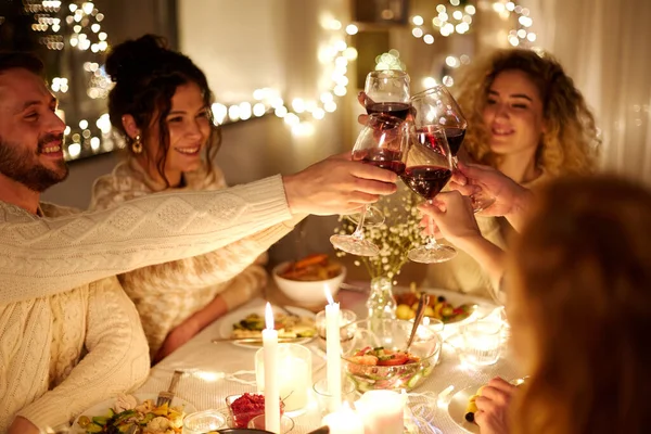 Happy friends drinking red wine at christmas party — Stock Photo, Image