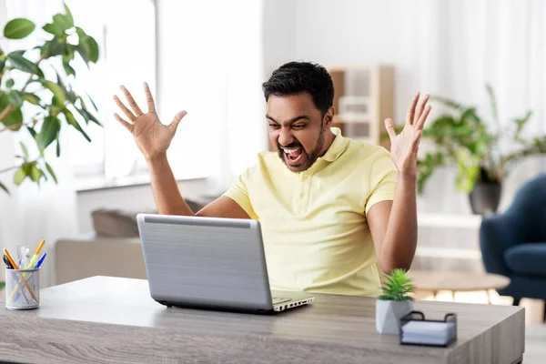 一个带着笔记本电脑在总公司工作的愤怒男人 — 图库照片