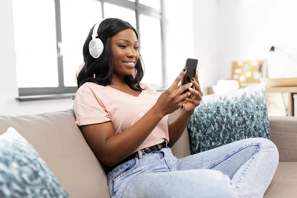Frau mit Smartphone hört zu Hause Musik — Stockfoto