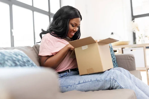 Afrikaans amerikaanse vrouw openen pakket doos thuis — Stockfoto