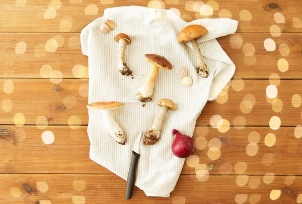 Eetbare paddenstoelen, keukenmes en handdoek — Stockfoto