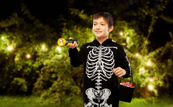 Boy in halloween costume with candies and torch — Stock Photo, Image