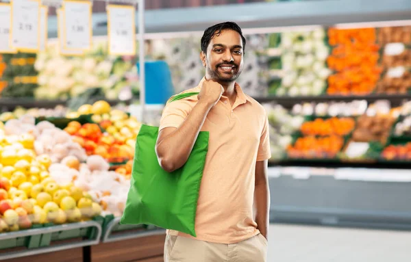 man with reusable canvas bag for food shopping