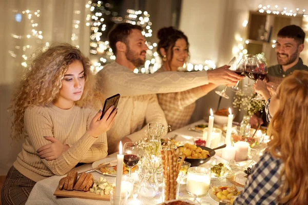 Femme avec smartphone au dîner avec des amis — Photo