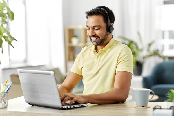 Hombre indio con auriculares y portátil trabajando en casa — Foto de Stock