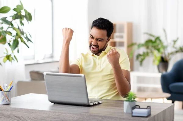 Hombre feliz con el ordenador portátil de trabajo en casa oficina — Foto de Stock
