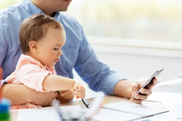 Πατέρας με μωρό και smartphone που εργάζονται στο σπίτι — Φωτογραφία Αρχείου