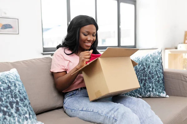 Afro-Amerikan kadın evde paket kutusu açıyor. — Stok fotoğraf