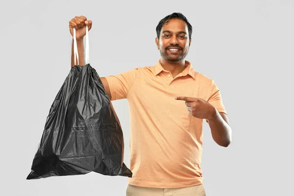 Усміхнений індійський чоловік тримає мішок для сміття — стокове фото