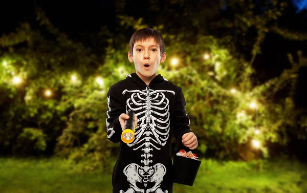 Jongen in halloween kostuum met snoep en fakkel — Stockfoto