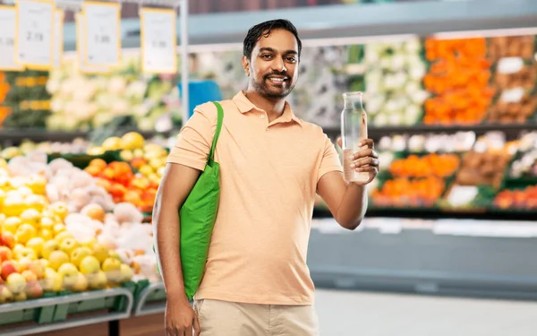 Homem com saco para compras de alimentos e garrafa de vidro — Fotografia de Stock