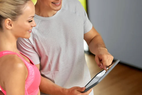 Close up of man and woman with tablet pc in gym — Stock Photo, Image