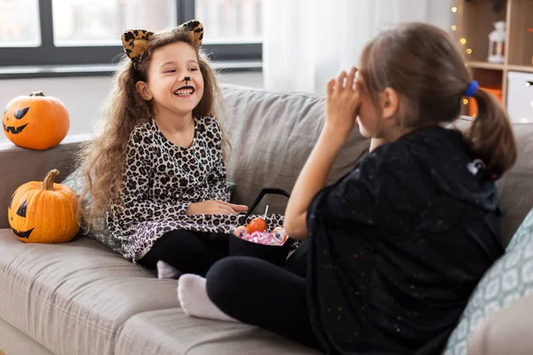 Girls in halloween costumes with candies at home — Stock Photo, Image