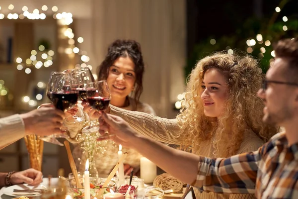 Amigos felizes bebendo vinho tinto na festa de Natal — Fotografia de Stock