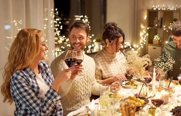 Amis heureux boire du vin rouge à la fête de Noël — Photo