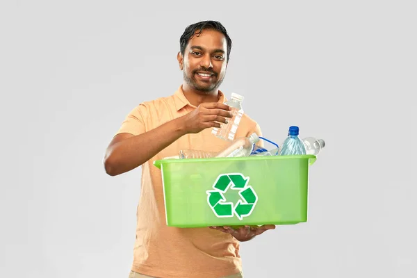 Mosolygó fiatal indiai férfi válogatás műanyag hulladék — Stock Fotó