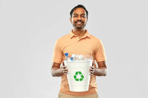 Sonriente joven indio hombre clasificación de residuos de plástico — Foto de Stock