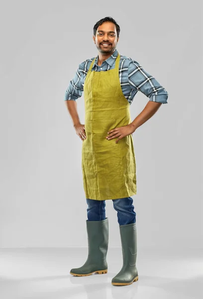 Happy indian male gardener or farmer in apron — Stock Photo, Image