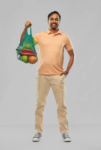 Glücklicher indischer Mann mit Lebensmitteln in wiederverwendbarer Netztasche — Stockfoto