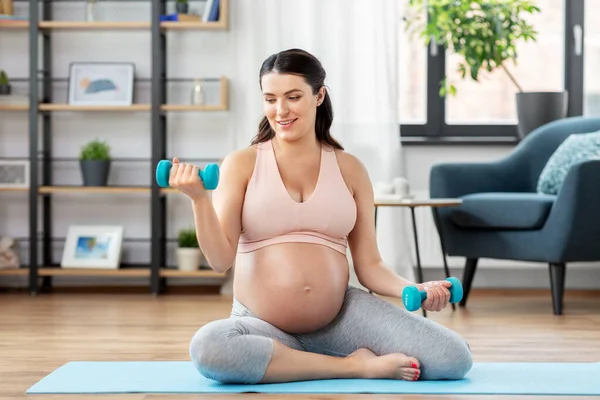 Zwanger vrouw met halters doet sport thuis — Stockfoto
