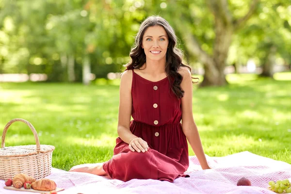 Lycklig kvinna med picknickkorg på sommarparken — Stockfoto