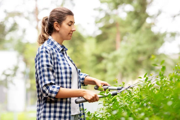 Vrouw met snoeirieten takken in de tuin — Stockfoto