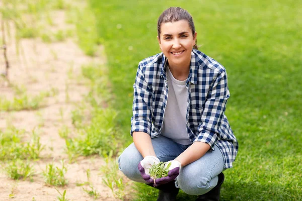 Vrouw wieden bloembed in de zomer tuin — Stockfoto