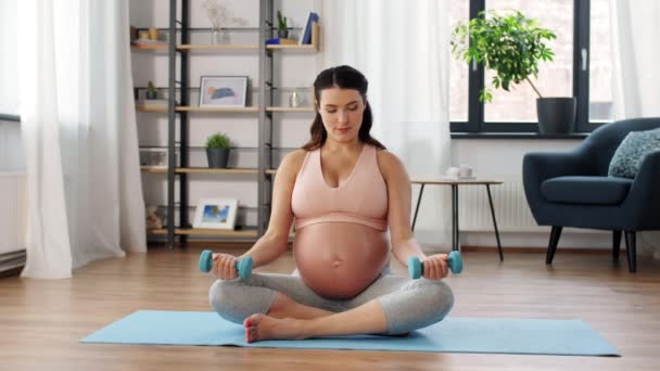 Mujer embarazada con mancuernas haciendo deportes en casa — Vídeo de stock