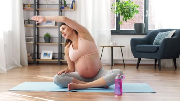 妊娠中の女性は家でヨガの後に水を飲む — ストック動画