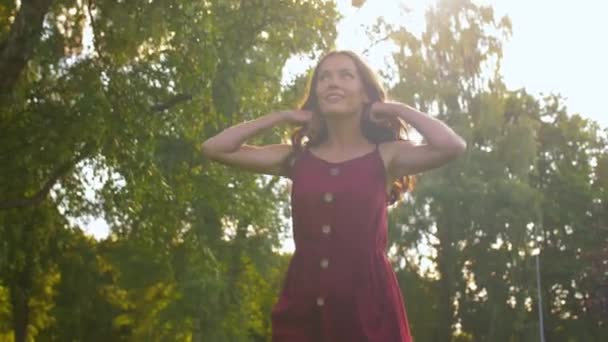 Šťastná usměvavá žena kráčející podél letního parku — Stock video
