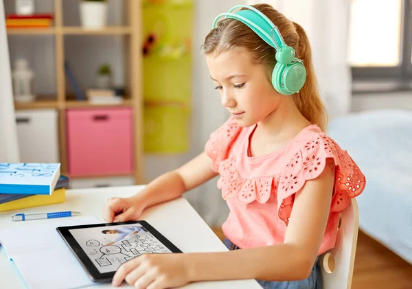 Девушка в наушниках с планшетным компьютером дома — стоковое фото